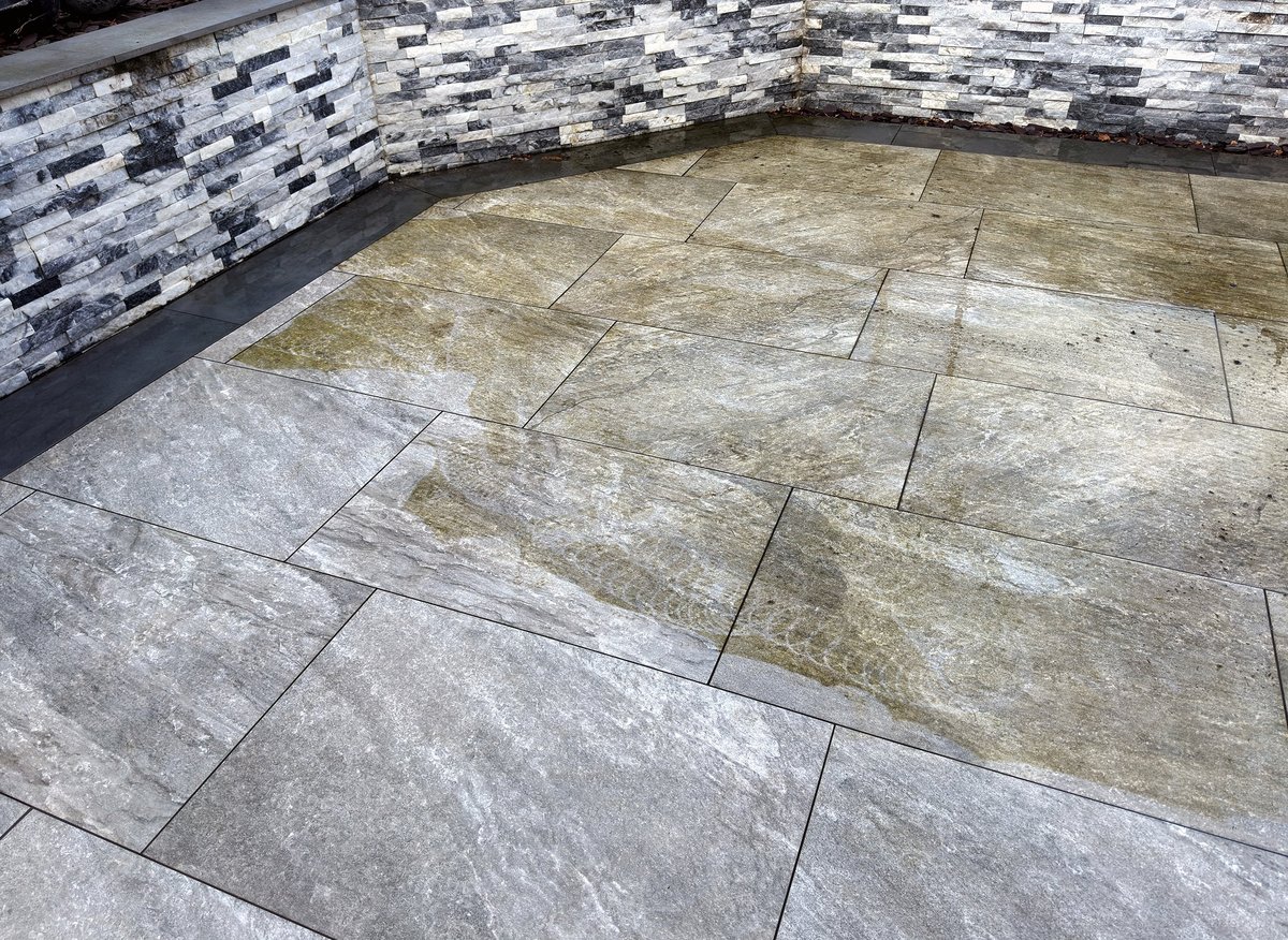 Contrast between clean and dirty parts of a garden patio after being pressure washed